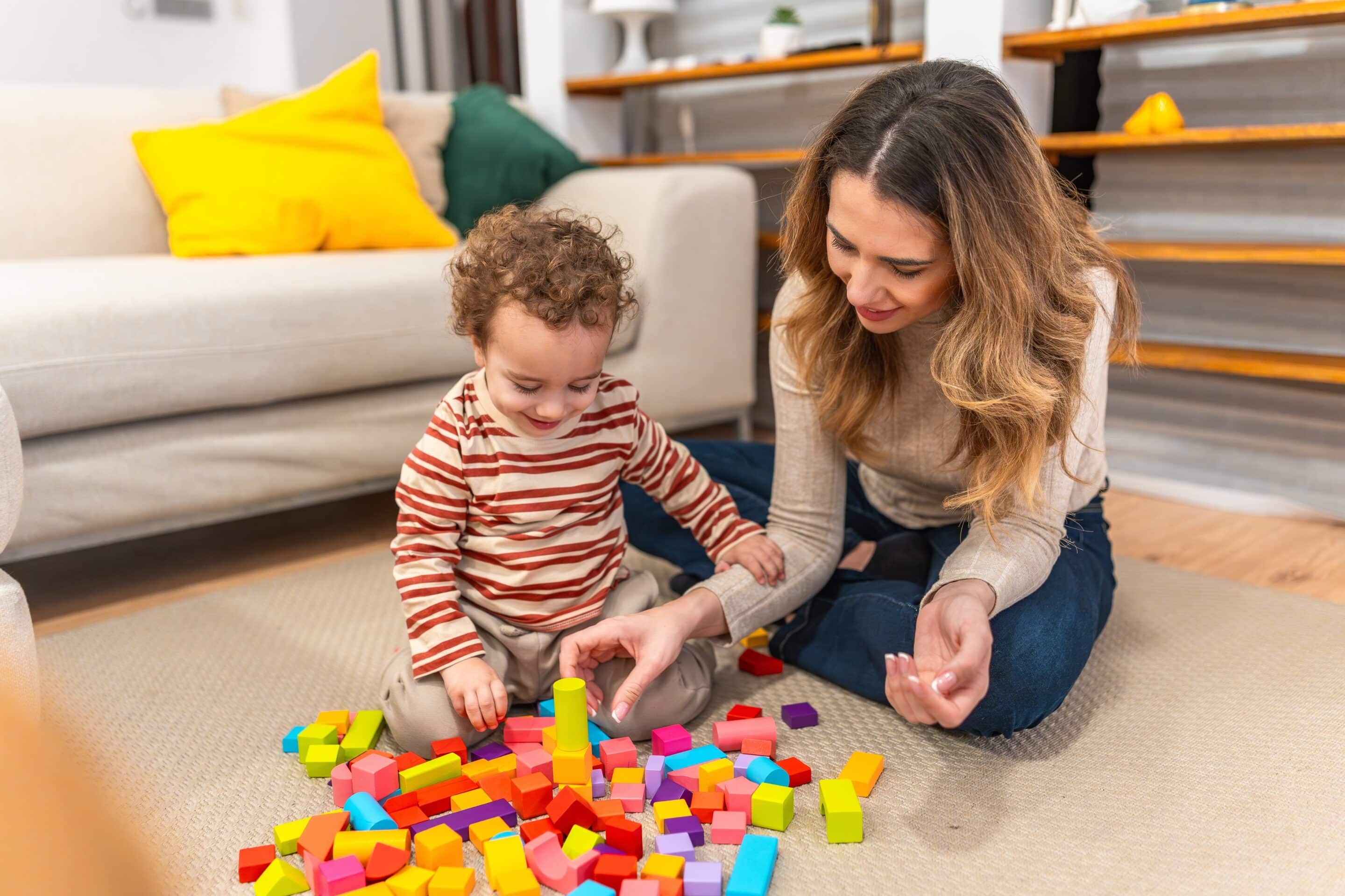 Criança autista sentada numa sala de terapia, rodeada de brinquedos sensoriais coloridos e um psicólogo anotando notas